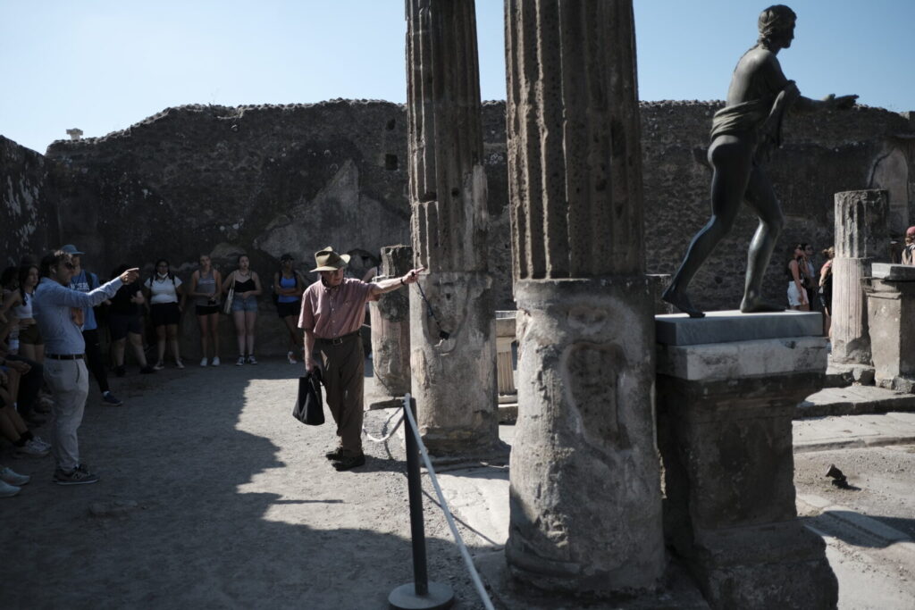 Man presenting in front of old columns.